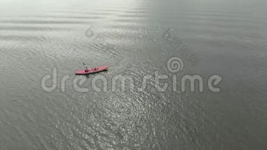 一个年轻人和他的儿子在海中或湖中的充气皮艇上划桨